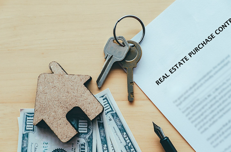 House keys, cash, and real estate purchase contract representing property investment in the market