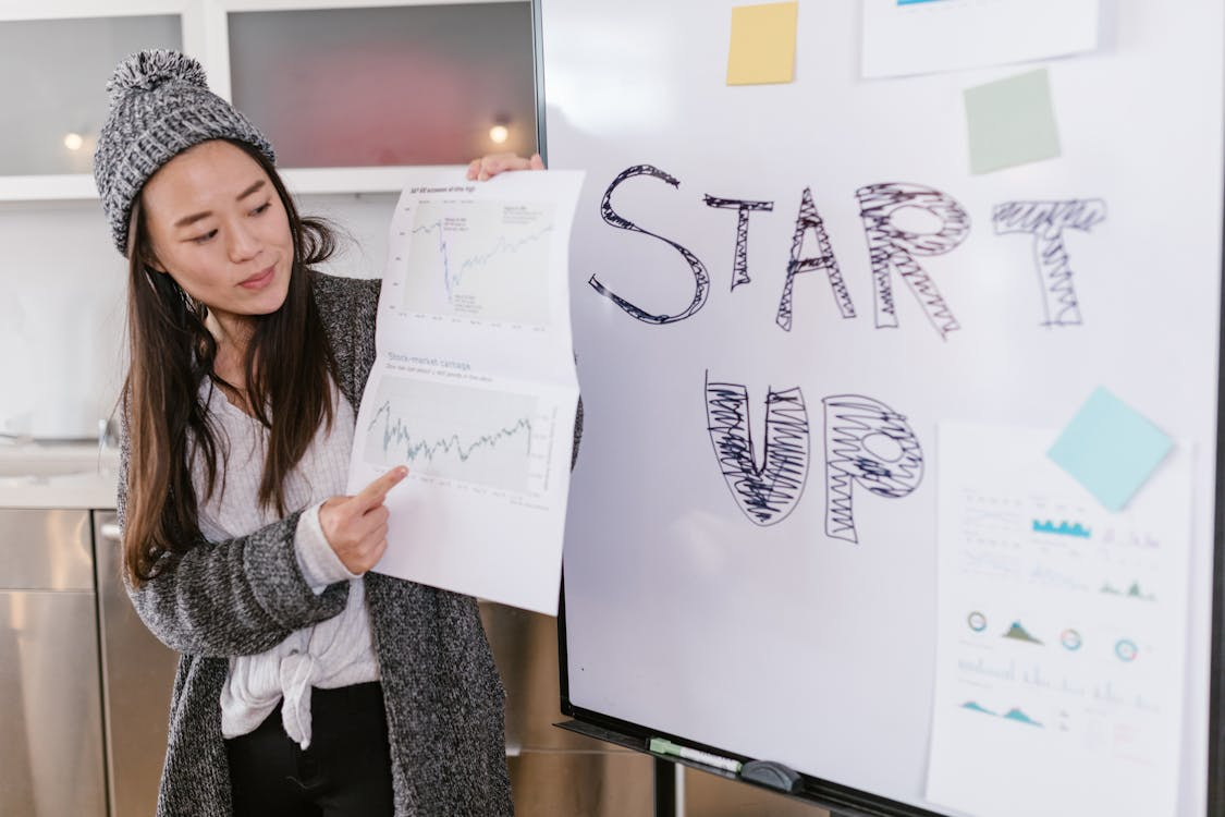 Female entrepreneur presenting financial charts during a startup pitch meeting