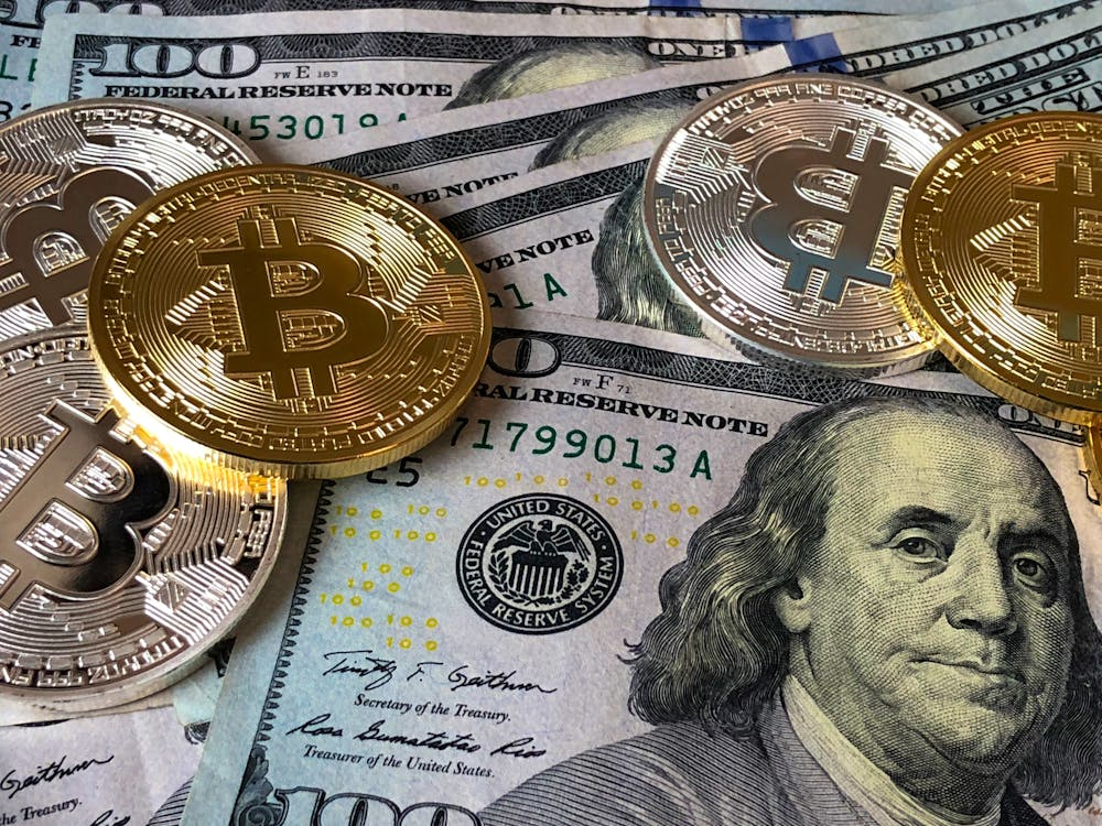 Bitcoin cryptocurrency coins placed on US dollar bills, representing crypto hype cycles