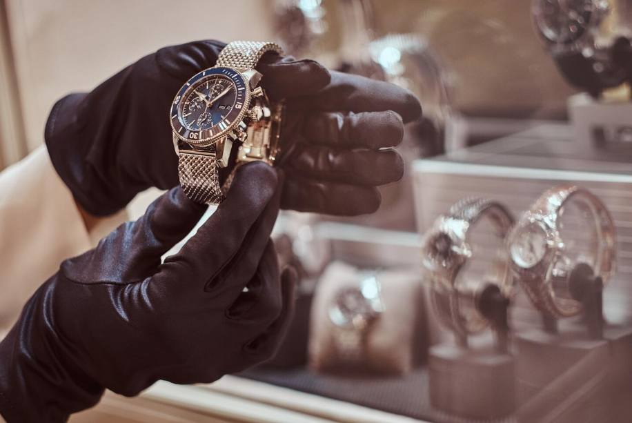 Gloved hands holding a luxury wristwatch that remains a top luxury asset that holds value
