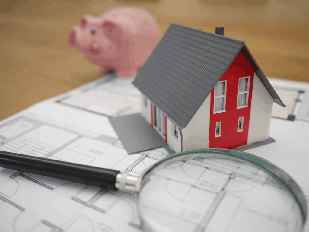Model house on estate planning documents with magnifying glass and piggy bank