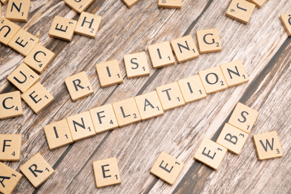 Scrabble tiles spelling out rising inflation, symbolizing how inflation erodes wealth.